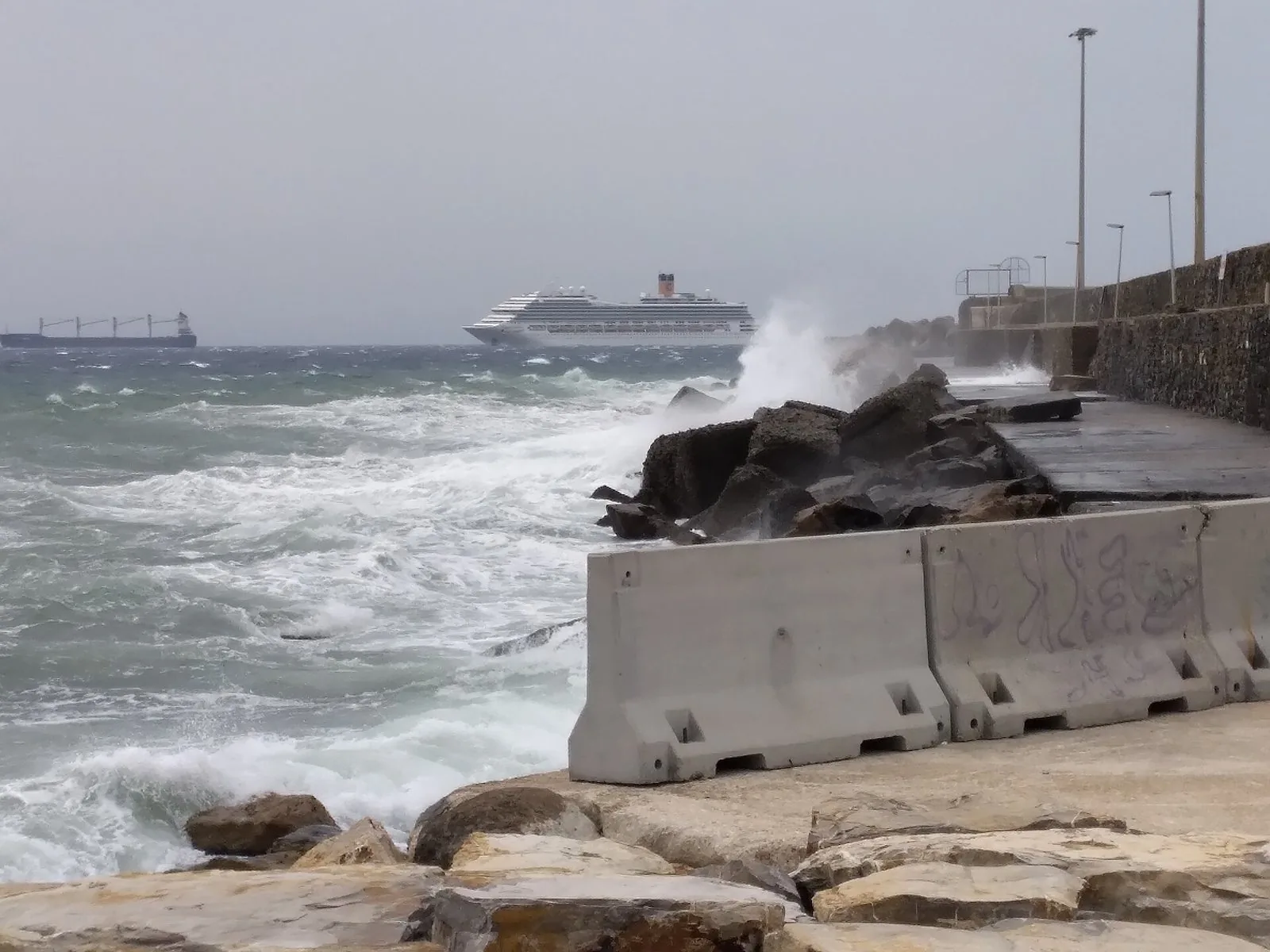 Mareggiata sul lungomare di Civitavecchia, con una nave al largo